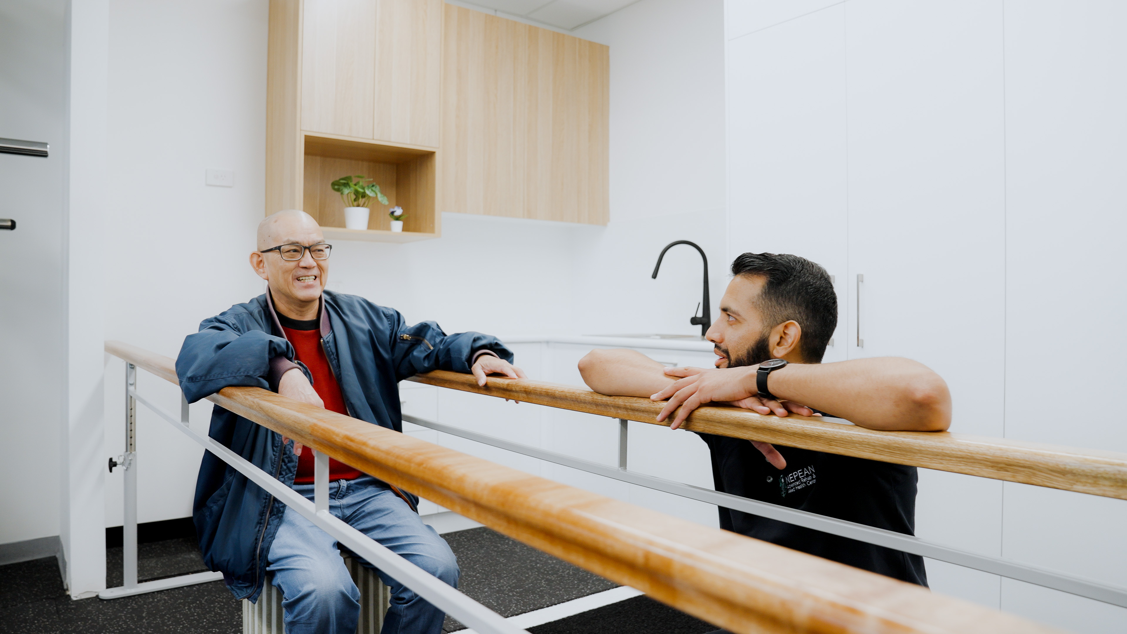Friendly parallel bars consultation between patient and therapist at Nepean Advanced Rehab